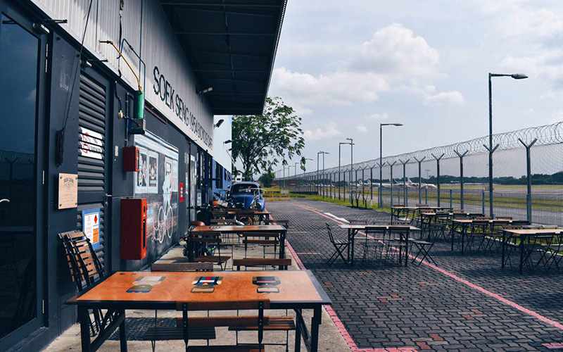 Enjoy a cuppa or a snack at the al fresco dining area of Soek Seng 1964 Bicycle Cafe for the best views of the Seletar Airport runway